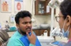 Patient discussing pain and bleeding in one gum spot with a dentist